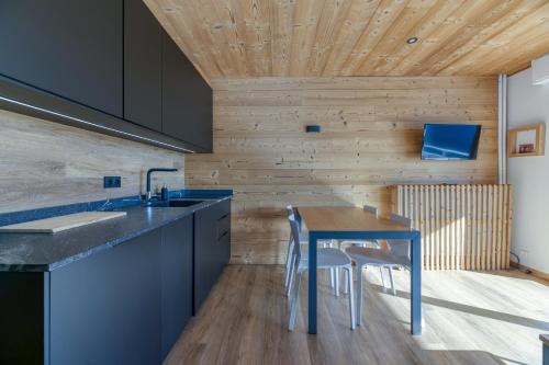 une cuisine avec des placards bleus et une table bleue dans l'établissement Homency - Résidence le Majestic N2, à L'Alpe-d'Huez