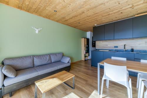 un salon avec un canapé et une table dans l'établissement Homency - Résidence le Majestic N2, à L'Alpe-d'Huez
