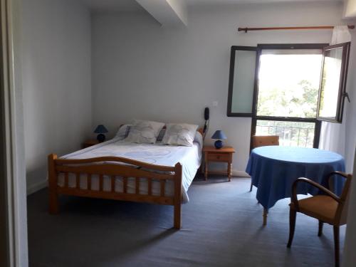 une chambre avec un lit, une table et une fenêtre dans l'établissement Relais du caudeau, à Lembras