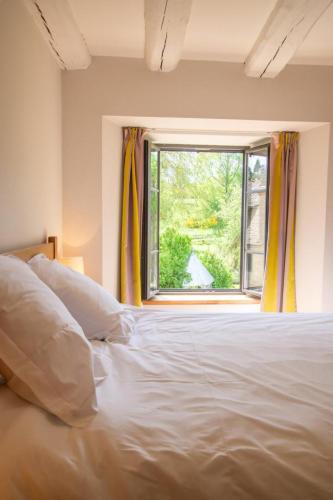 a bedroom with a white bed and a window at Gites de france 24 personnes - domaine de coulagnettes in Serverette