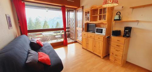 un salon avec un canapé et une grande fenêtre dans l'établissement HAVRE DE PAIX AU COEUR DES PYRENNEES A GUZET, à Ustou