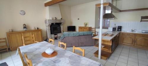 eine Küche und ein Esszimmer mit einem Tisch und einem Herd in der Unterkunft Gites de france a tresbos in Laval-Atger