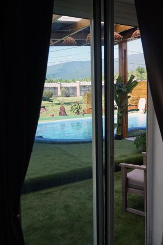 a view of a swimming pool from a window at La VOLCANAISE in Village Sainte Anne