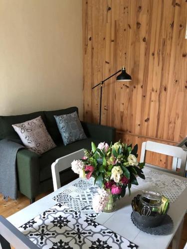 un salon avec une table avec un vase de fleurs dans l'établissement Petite maison à la mer, à Fort-Mahon-Plage