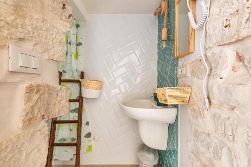 a bathroom with a sink and a toilet at Trullo DoMi by Perle di Puglia in Noci