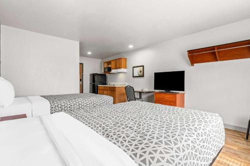 a hotel room with two beds and a television at WoodSpring Suites Tulsa in Tulsa