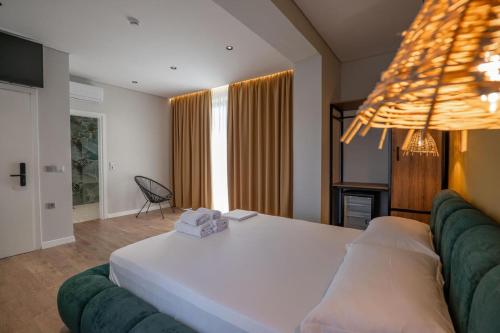 a bedroom with a large white bed and a couch at JUER Hotel in Bajkaj