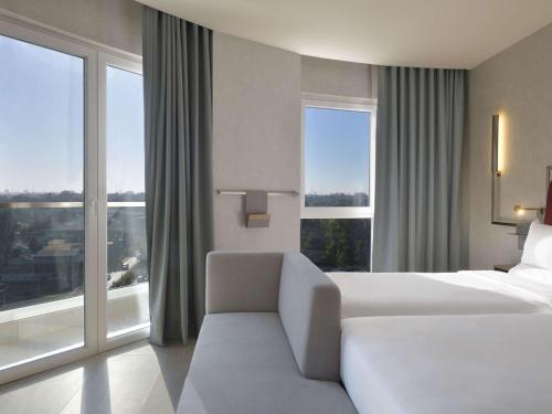 a hotel room with a bed and a large window at Novotel Lubumbashi in Lubumbashi