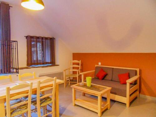 a living room with a couch and a table and chairs at Lou cayrat a bagnols les bains in Bagnols-les-Bains