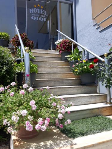 a set of stairs with flowers in front of a building at Qiqi Hotel in Gjirokastër