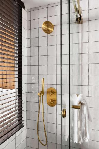 a bathroom with a shower with a glass door at Grayson Hotel in New York