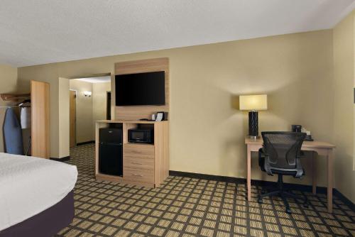 a hotel room with a bed and a desk with a computer at Clarion Pointe Bloomington-Normal near I-55 and University in Bloomington