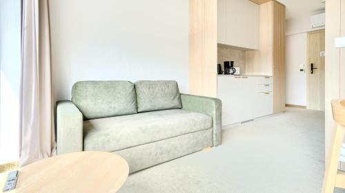 a living room with a couch and a kitchen at Prywatne apartamenty w Sea Shell, Sun & Snow in Łukęcin
