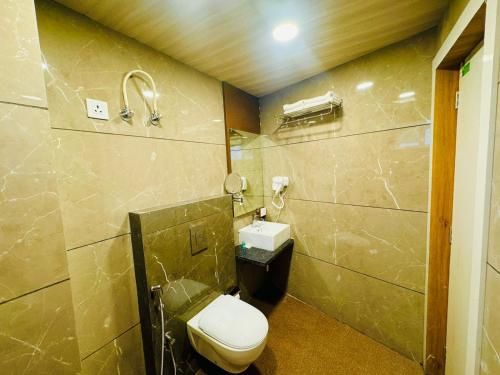 a bathroom with a toilet and a sink at Hotel Najaf Palace in Ajmer