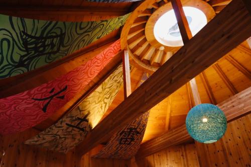 a room with a wooden ceiling with paintings on it at GRAND CHARIOT Hokutoshichisei 135° in Awaji