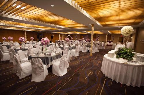a banquet hall with white tables and chairs and flowers at Edmonton Hotel & Convention Center Edmonton in Edmonton