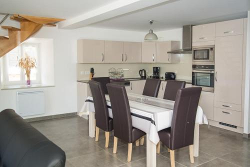 - une cuisine avec une table à manger et des chaises dans l'établissement Gite du bas au cayre, à Mas-dʼOrcières