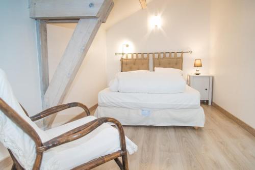 une chambre avec un lit blanc et une chaise dans l'établissement Gite du haut au cayre, à Mas-dʼOrcières