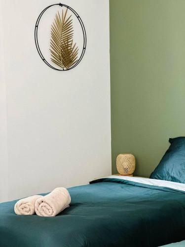 une chambre avec un lit avec des serviettes dessus dans l'établissement Laon'Vert, à Laon