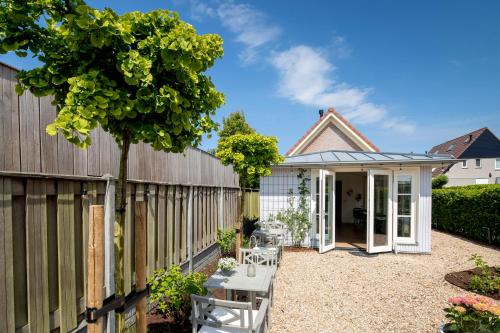 a garden with a fence and a table and chairs at Hotel Villa Vida in Domburg