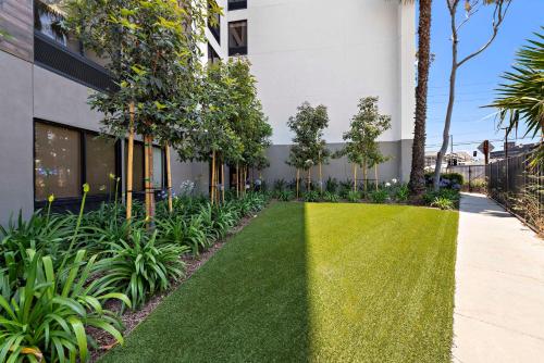a green lawn in front of a building at Hampton Inn Los Angeles Airport in Los Angeles