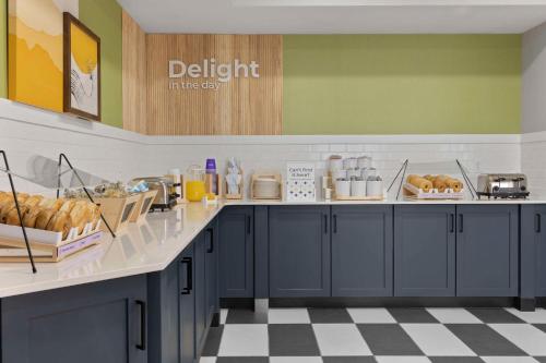 a kitchen with blue cabinets and a checkered floor at Spark By Hilton Newcomerstown in Newcomerstown