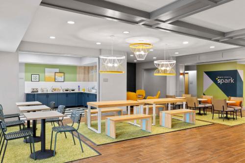 a rendering of a cafeteria with tables and chairs at Spark By Hilton Newcomerstown in Newcomerstown