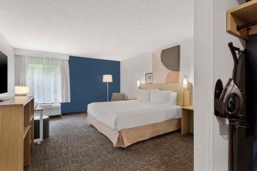 a hotel room with a bed and a television at Spark By Hilton Newcomerstown in Newcomerstown