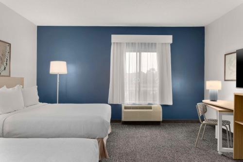 a hotel room with two beds and a window at Spark By Hilton Newcomerstown in Newcomerstown