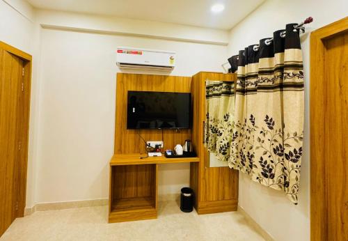 a living room with a television and a curtain at Hotel Najaf Palace in Ajmer