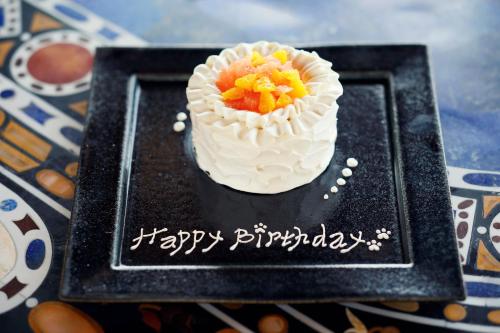 a cake on a black plate with a happy birthday at GRAND CHARIOT Hokutoshichisei 135° in Awaji