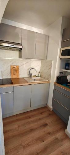 une cuisine avec des armoires blanches et un évier dans l'établissement La Balagne ça nous gagne, à Algajola