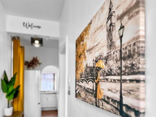 a painting of a woman with an umbrella on a wall at Stylish House Near Hospital with Free Parking in Stoke on Trent