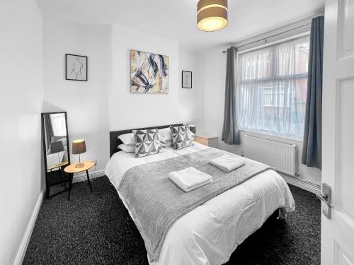 a white bedroom with a large bed and a window at Stylish House Near Hospital with Free Parking in Stoke on Trent