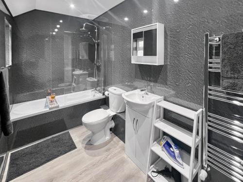 a bathroom with a toilet and a sink and a shower at Stylish House Near Hospital with Free Parking in Stoke on Trent