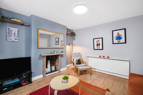 a living room with a tv and a fireplace at Pass the Keys Private Garden Apartment by Tulse Hill Station in London