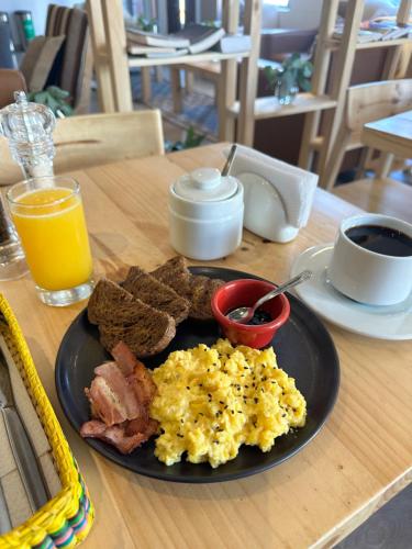 a plate of eggs bacon and toast and a glass of orange juice at CASA CRISTOBAL Centenario in Cusco