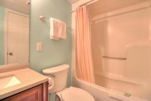 a bathroom with a toilet and a shower and a sink at 1114 Boundless Awe by Atlantic Towers in Carolina Beach