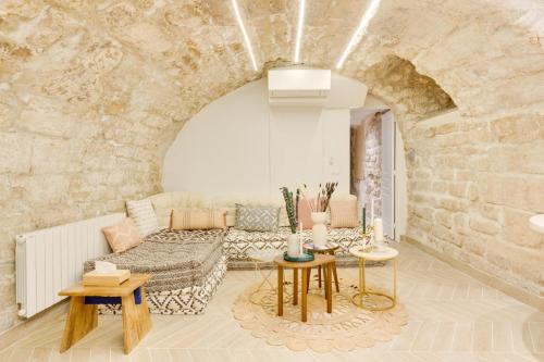 un salon avec un canapé et un mur en pierre dans l'établissement Opera Hypercenter, Spa & 3 Bedrooms 6 people, à Paris