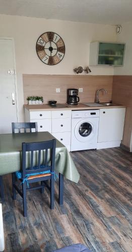 une cuisine avec une table et une machine à laver dans l'établissement Vacances à Narbonne Plage !, à Narbonne