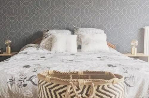 - un lit avec une couette et des oreillers blancs dans l'établissement Levallois-Perret -Porte de Paris, à Levallois-Perret