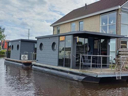 a house on a boat on a river at Bed-on-a-Boat in Giethoorn