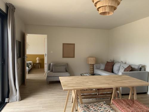 un salon avec une table et un canapé dans l'établissement La cabane, à Beaurepaire
