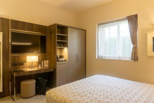 a bedroom with a bed and a window at Hotel Kuma in San Giuseppe