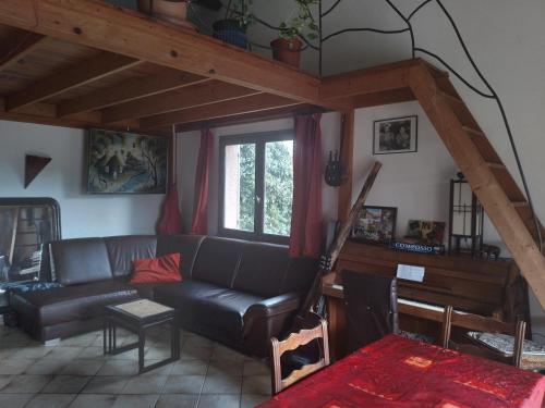 - un salon avec un canapé noir et une fenêtre dans l'établissement maison de vacances à Paulhan, à Paulhan