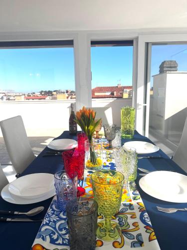 a table with colorful glass vases and plates on it at ROMA AIRPORT SKY Apartments in Fiumicino