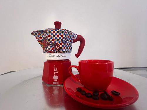 a red coffee maker and a red cup on a table at ROMA AIRPORT SKY Apartments in Fiumicino