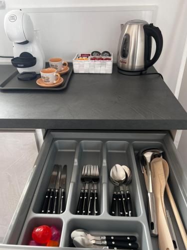 a drawer in a refrigerator filled with utensils at ROMA AIRPORT SKY Apartments in Fiumicino