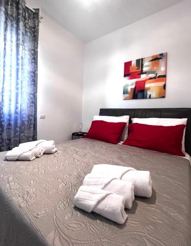 a bedroom with a large bed with towels on it at ROMA AIRPORT SKY Apartments in Fiumicino