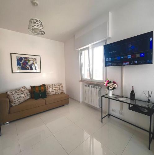 a living room with a couch and a flat screen tv at ROMA AIRPORT SKY Apartments in Fiumicino